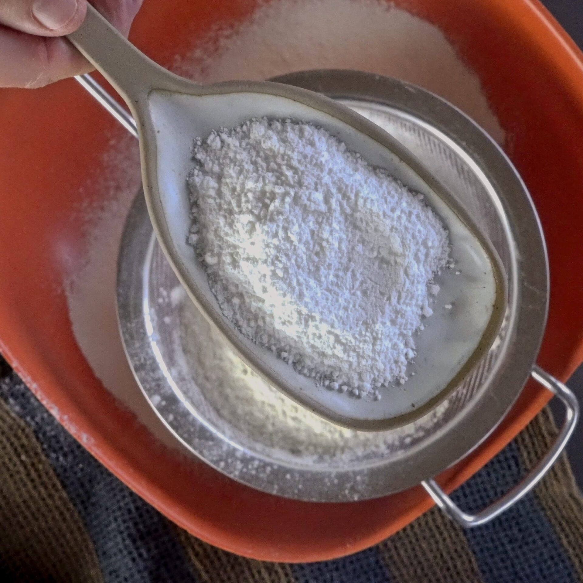 Adding baking powder to the flour for making roti dough.