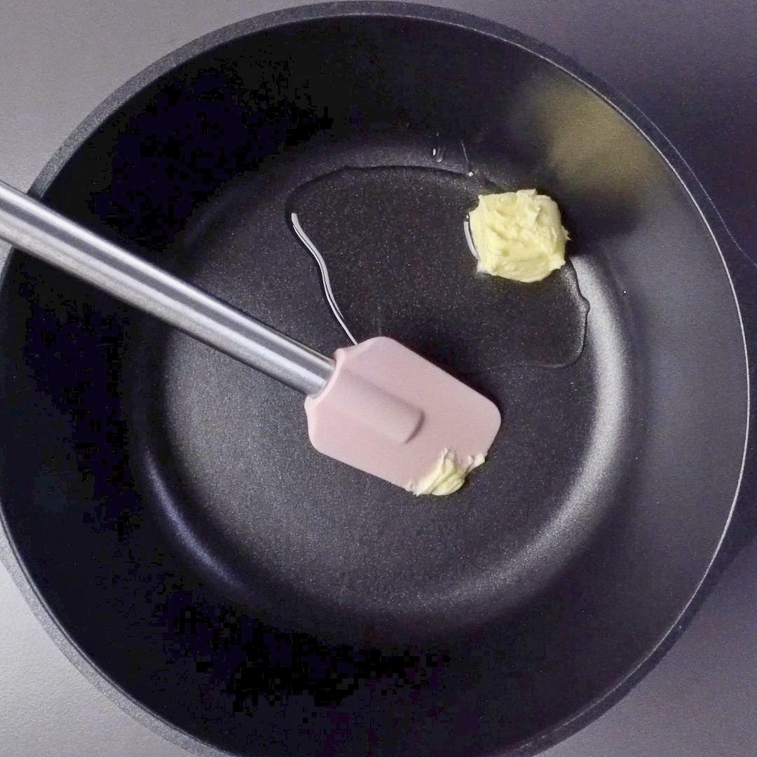 Adding butter and oil to a pot for cooking.