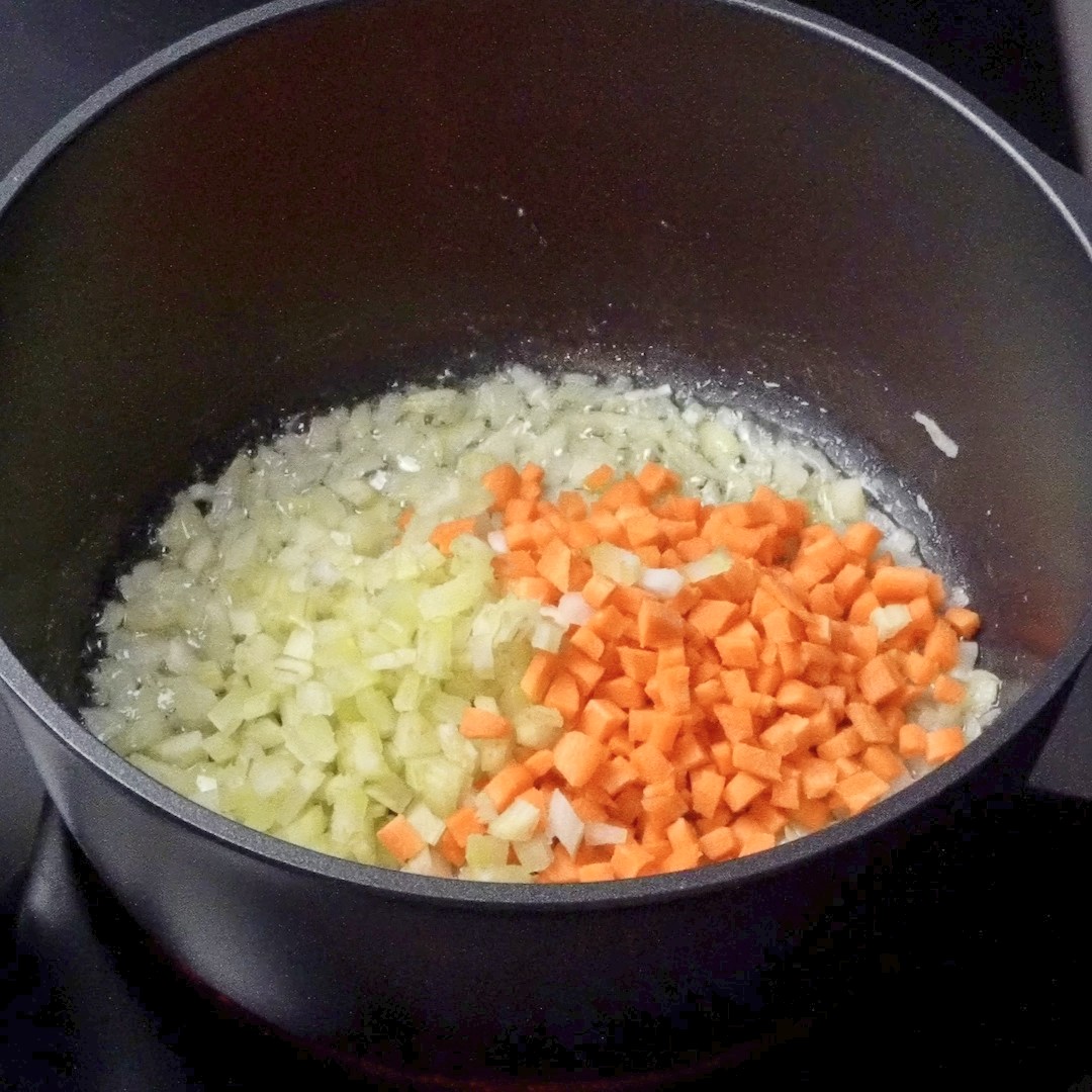 Adding carrots and celery to the pot.