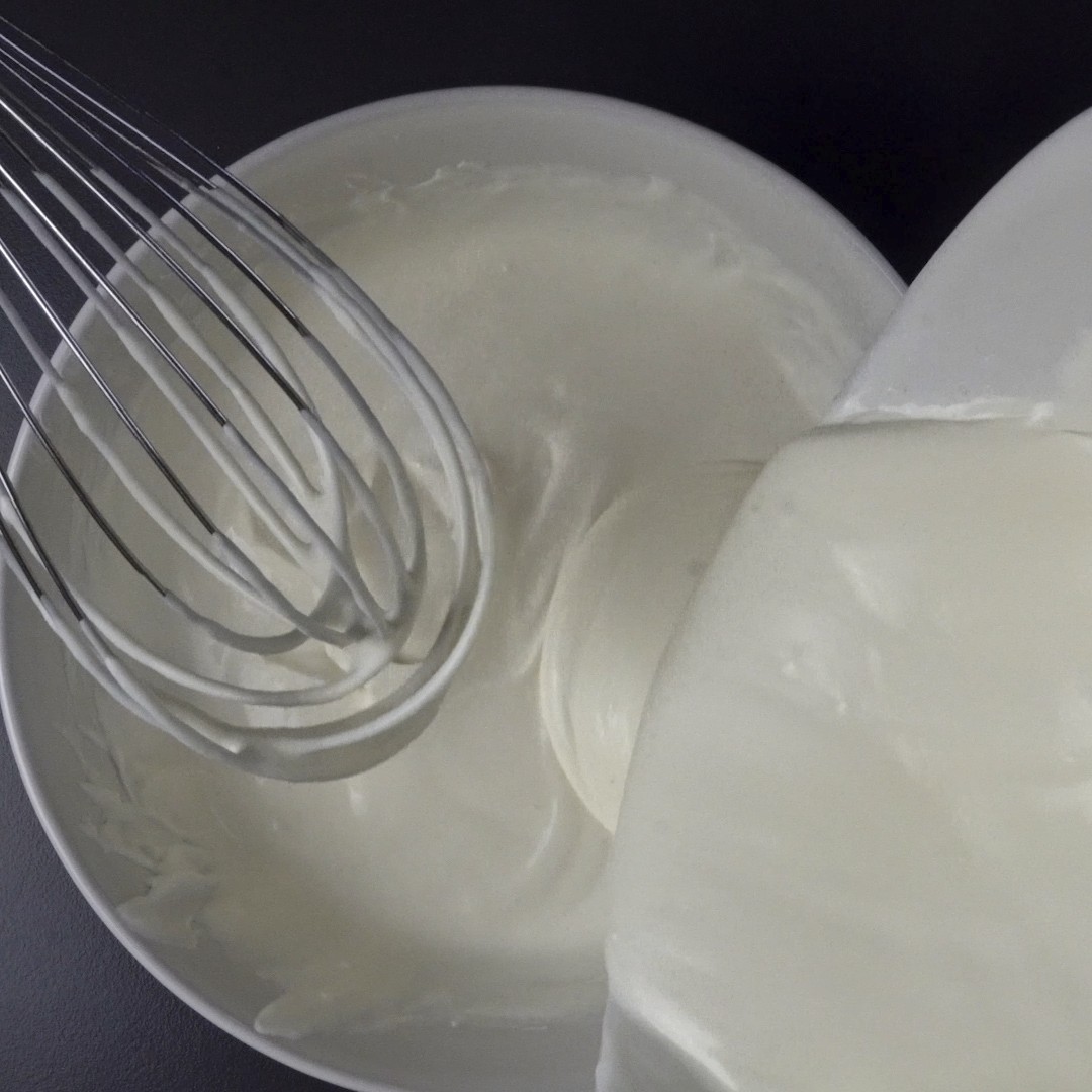 Pouring heavy cream and sour cream into the flour.