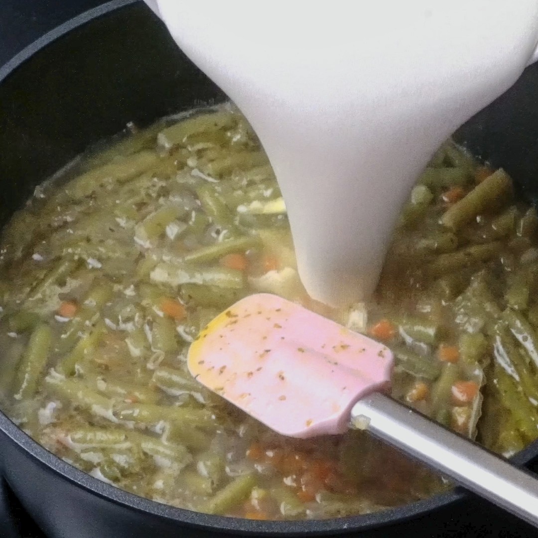 Pouring the creamy mixture into the soup.