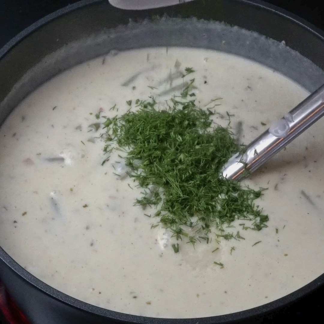 Adding fresh dill to the soup for extra flavor.