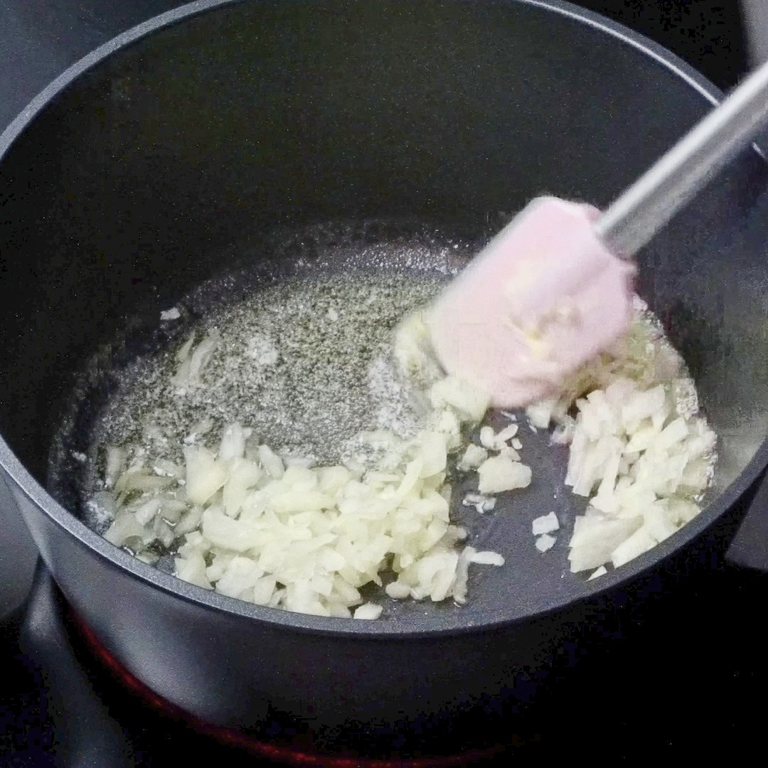 Adding chopped onion to the pot.