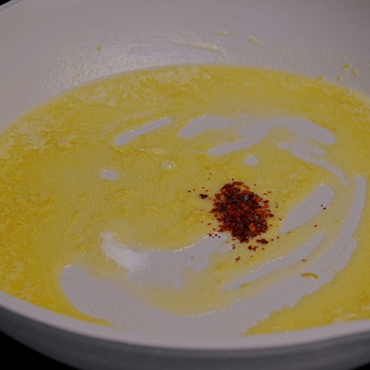 Adding spices to melted butter in a pan.
