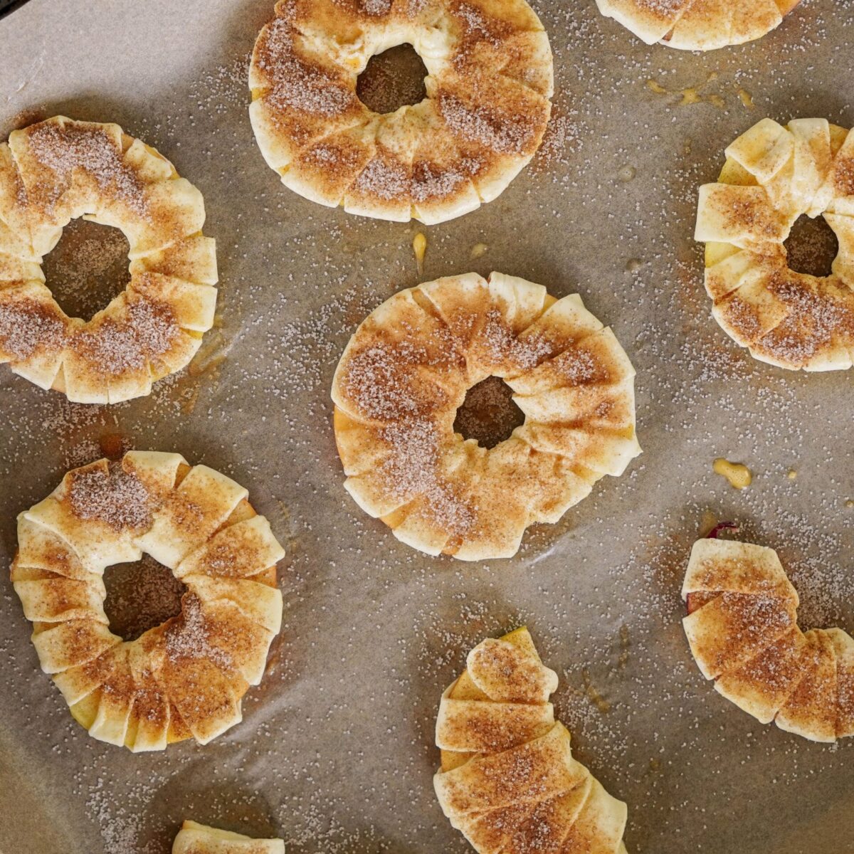 A raw puff pastry dessert displayed on parchment paper, ready to be placed in the oven.