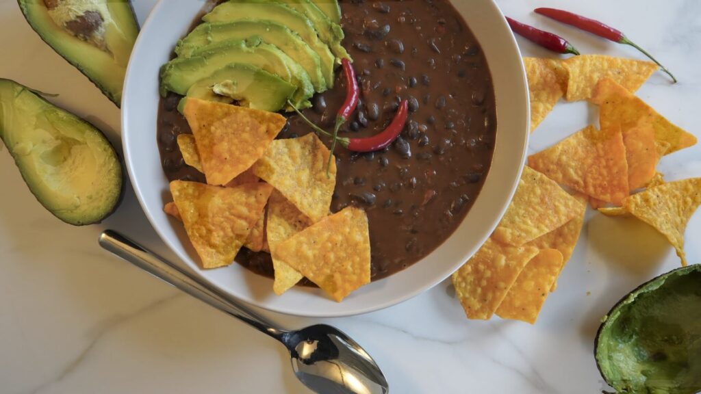 Black bean soup topped with crispy tortilla chips and soft avocado. 