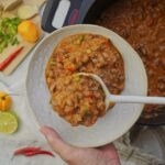 Pouring creamy black-eyed pea soup into a bowl with a ladle.