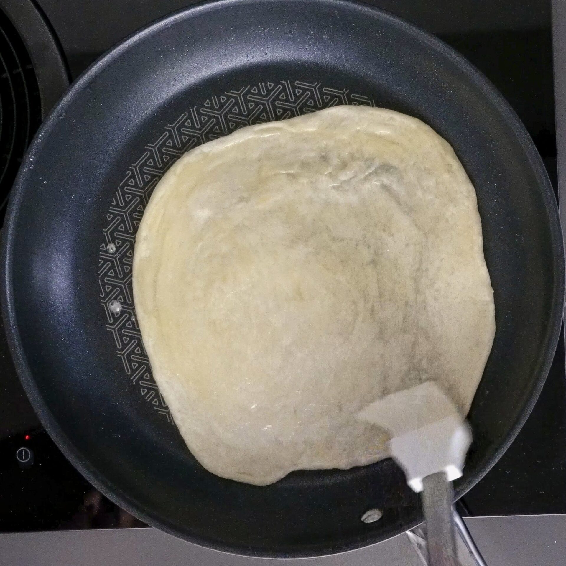 Brushing oil and butter on roti to keep it soft and flaky.
