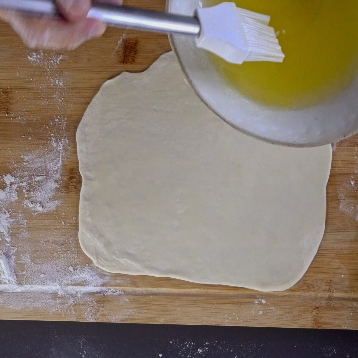 Brushing the dough with butter and oil for the second method.