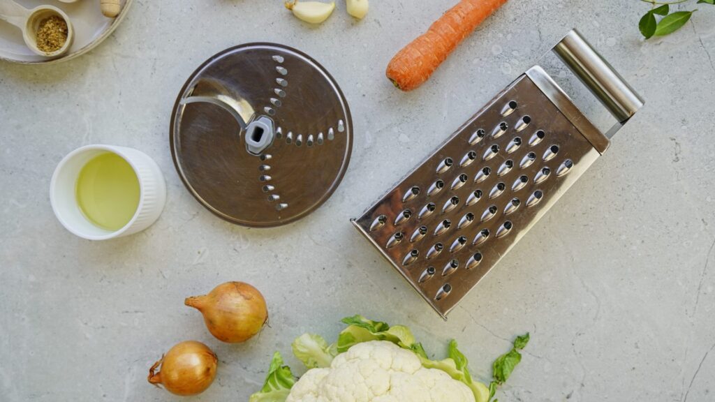 Showing best grater for cauliflower rice. There are 2 examples - regular four-sided grater and processor grater. Both have large holes. 