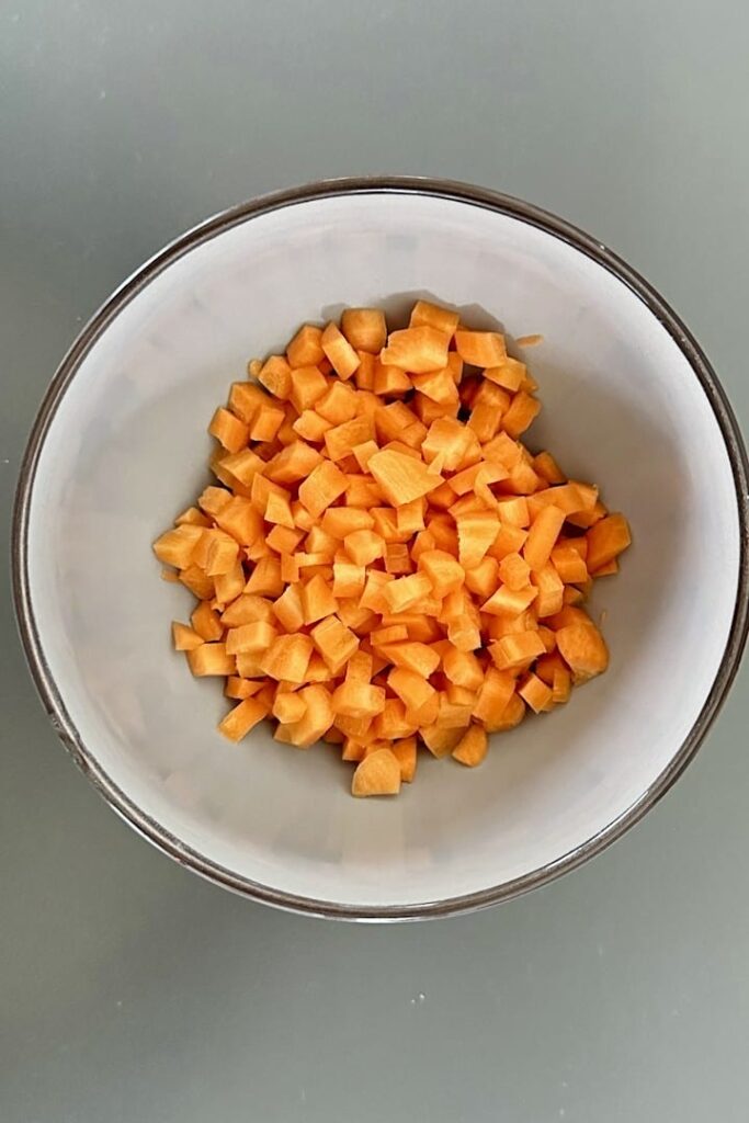 Cutting carrots into cubes for cauliflower rice.
