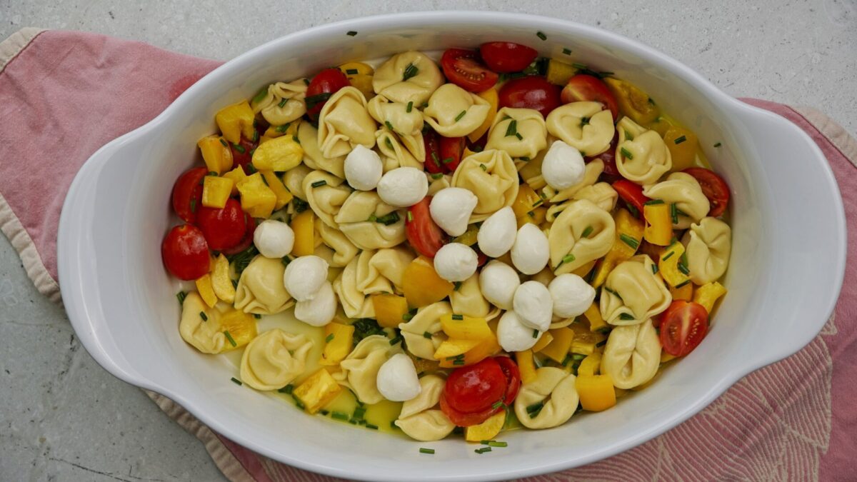 Adding mozzarella balls to salad.