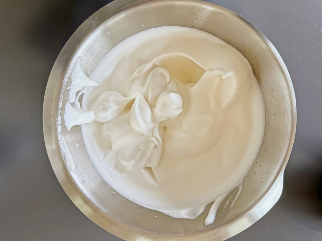 Whipping aquafaba into white creamy and very fluffy texture.