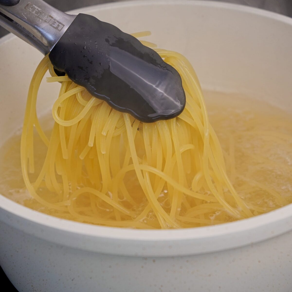Cooking spaghetti in a pan with boiling water.