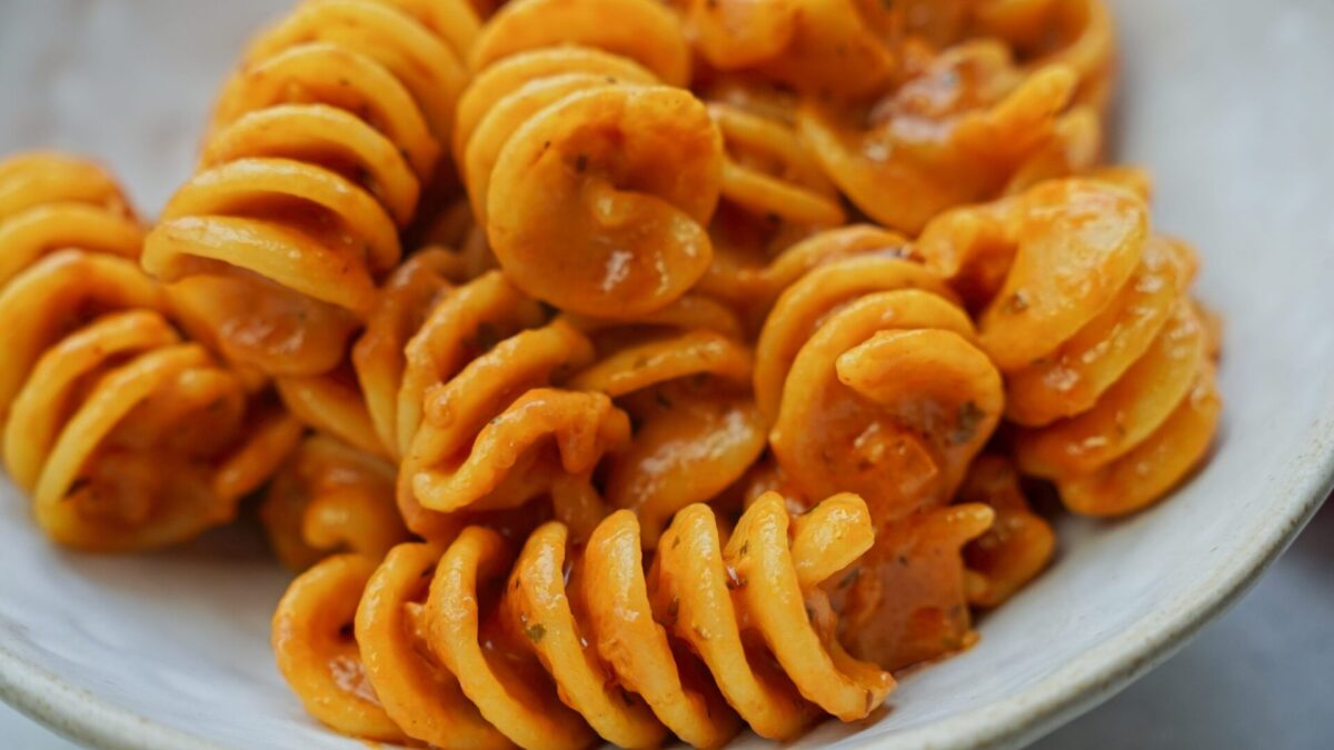 Close-up of fusilli pasta coated in creamy tomato sauce.