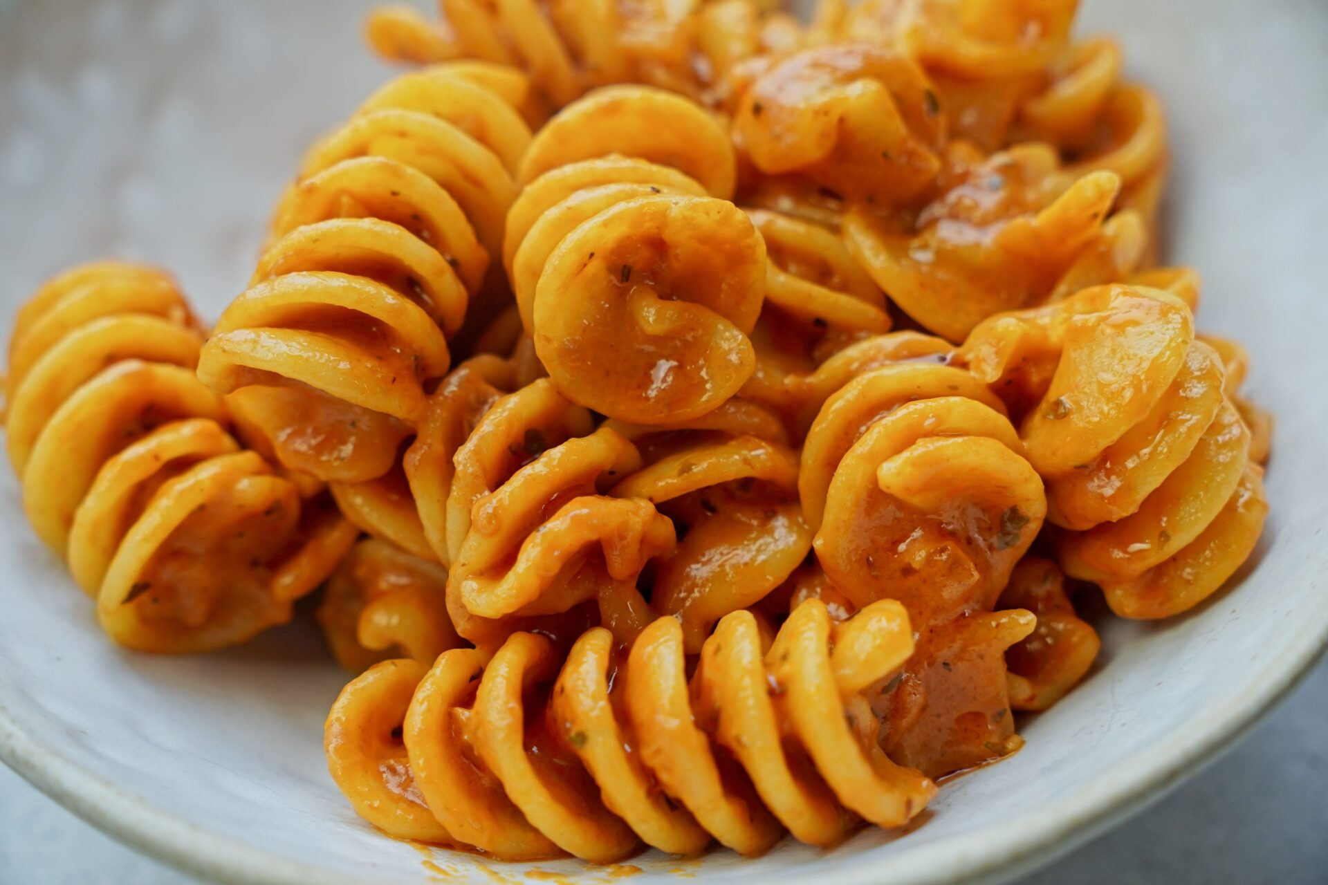 Close-up of fusilli pasta coated in creamy tomato sauce.
