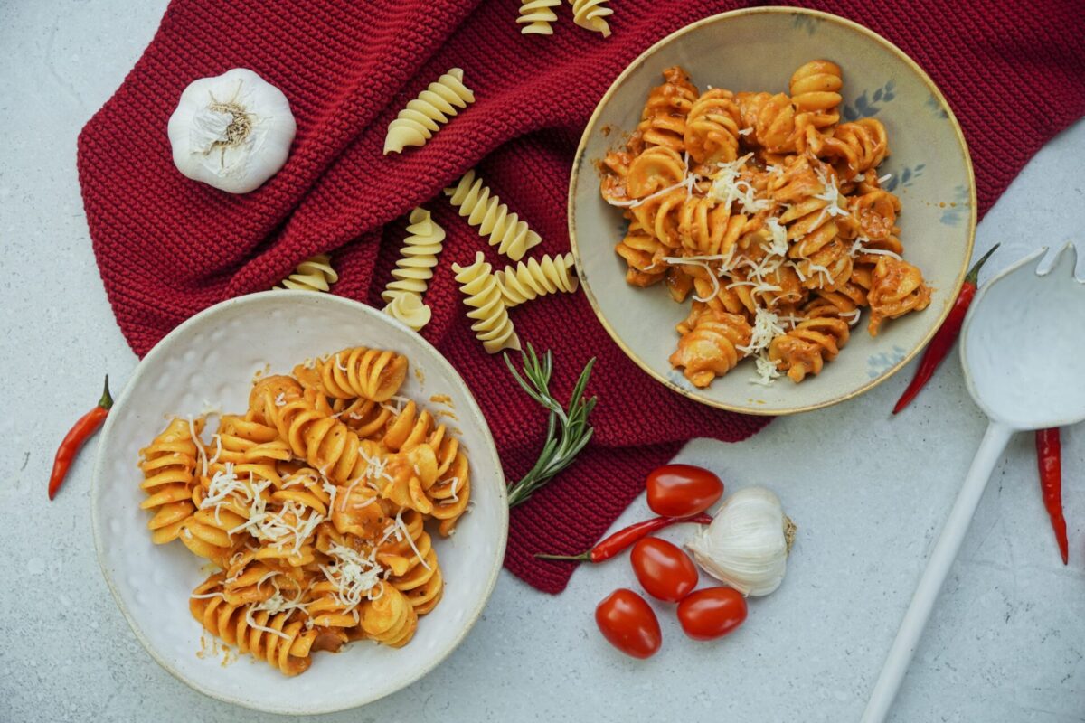 Creamy tomato sauce made with tomato paste and heavy cream, topped with sprinkled cheese.
