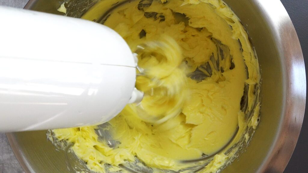 Mixing butter with a mixer to prepare cookie dough.