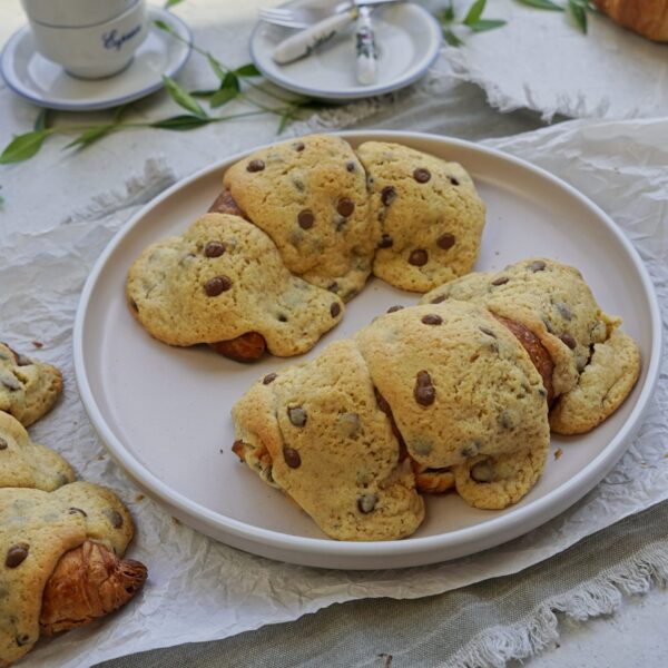 Freshly baked croissant cookie on a plate with crispy cookie dough topping.