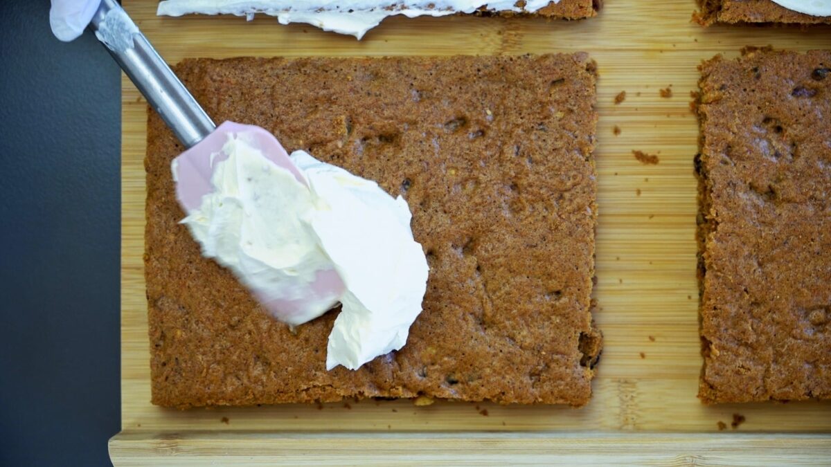 Frosting the carrot cake layers after they’ve been defrosted.