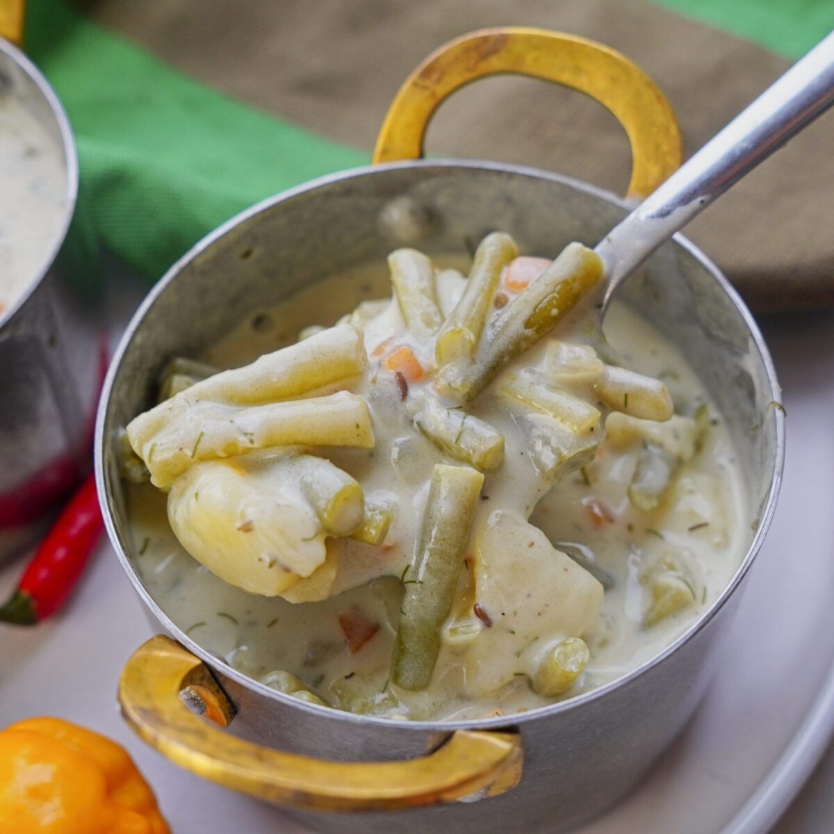 Eating green bean soup with a spoon, savoring every bite.