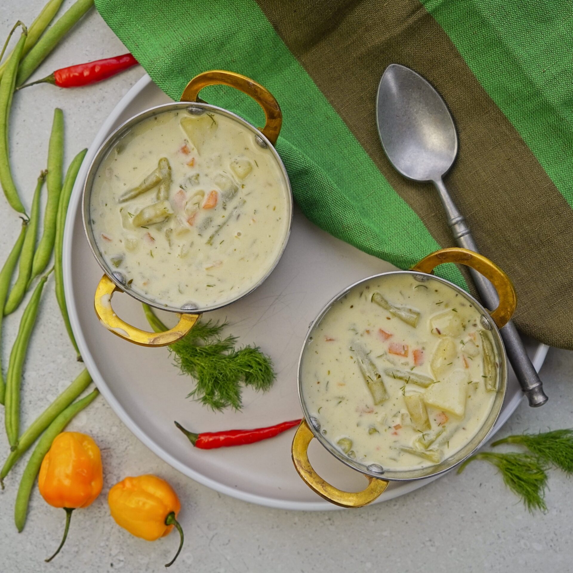 Creamy green bean soup in two small pots, ready to enjoy.