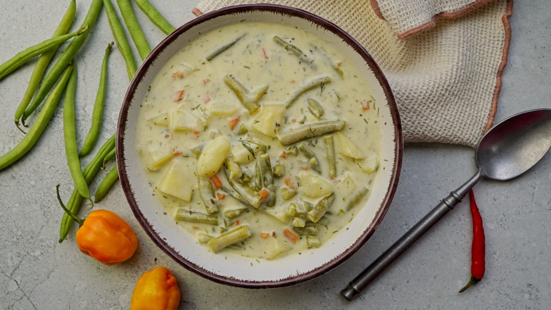 Top-down view of green bean soup with tender beans and potatoes.