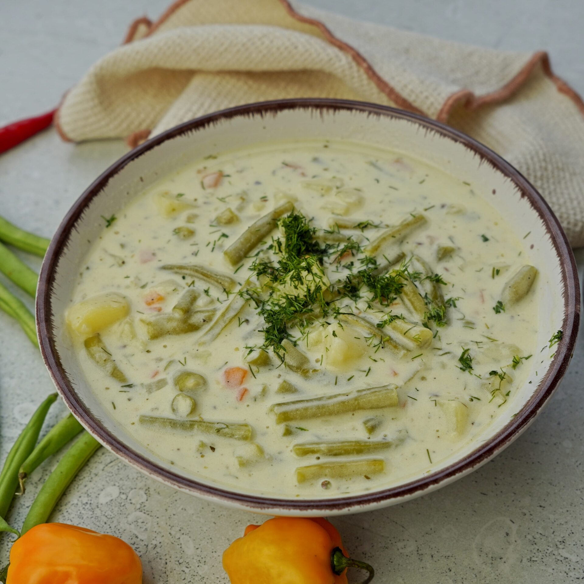 Freshly cooked green bean soup topped with chopped dill.