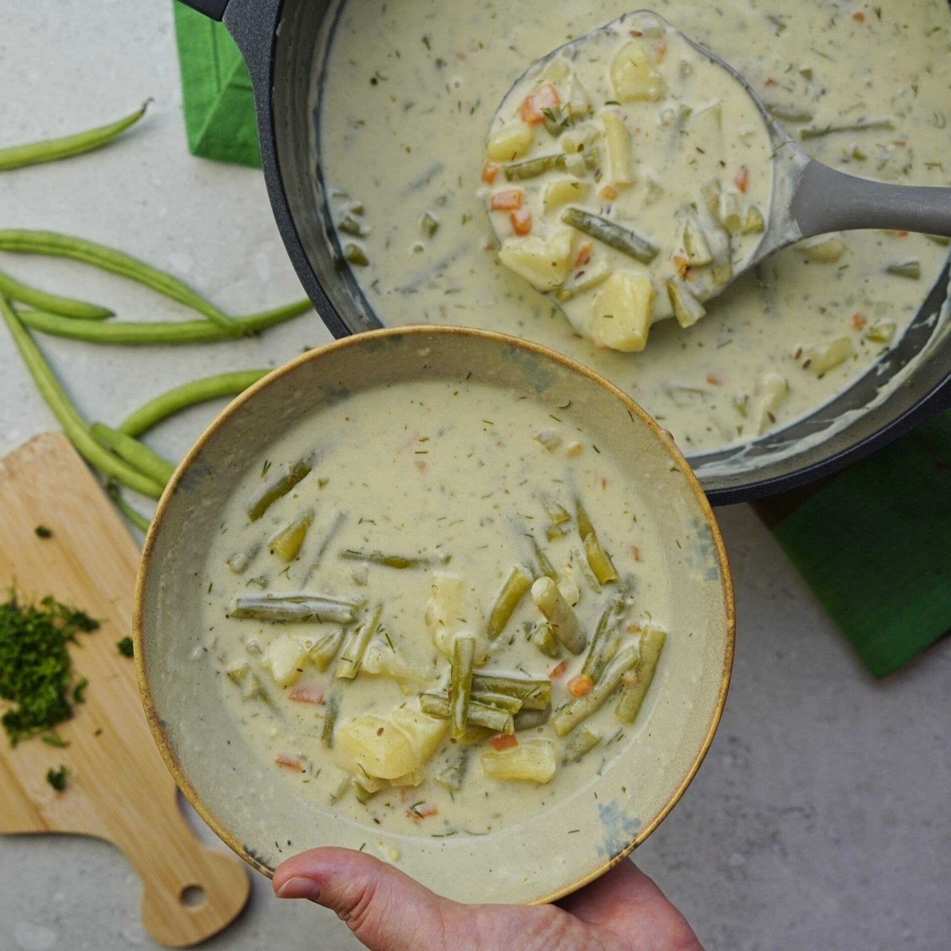 Fresh green beans in soup, cooked to a light green color.