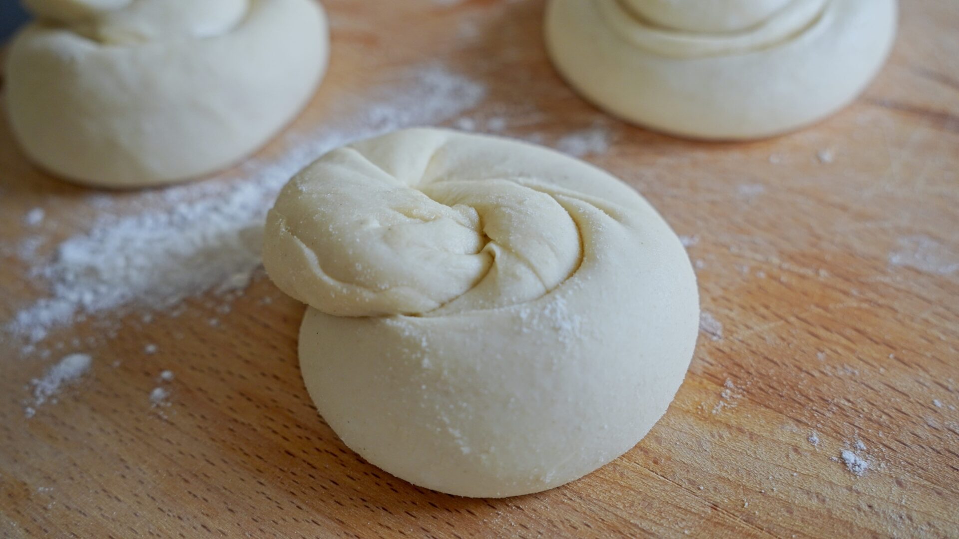 Shaping the dough into traditional roti forms before rolling it out.