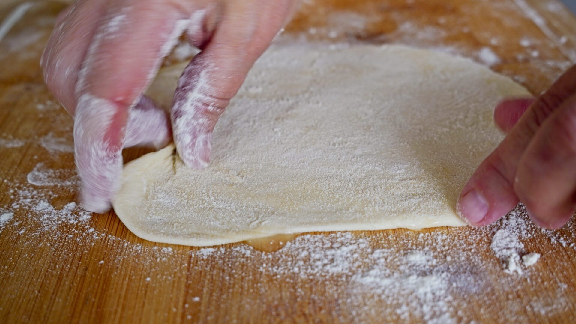 Rolling the dough into a thin layer, ready for cooking.