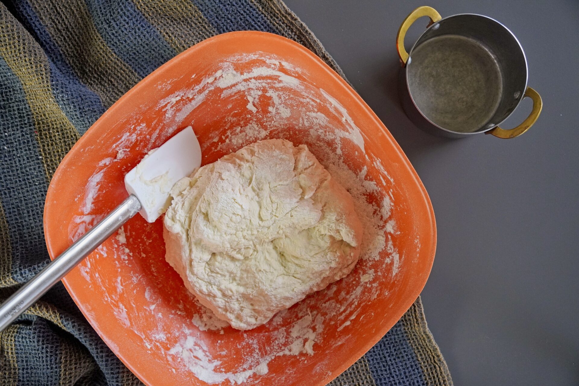Roti dough resting in a large bowl, ready for preparation.