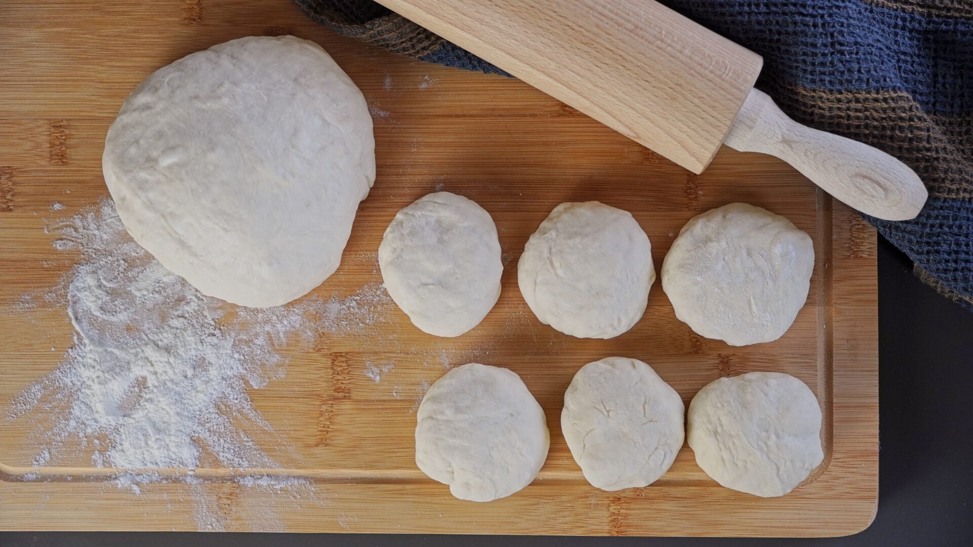 Roti dough balls lined up, ready to roll out.