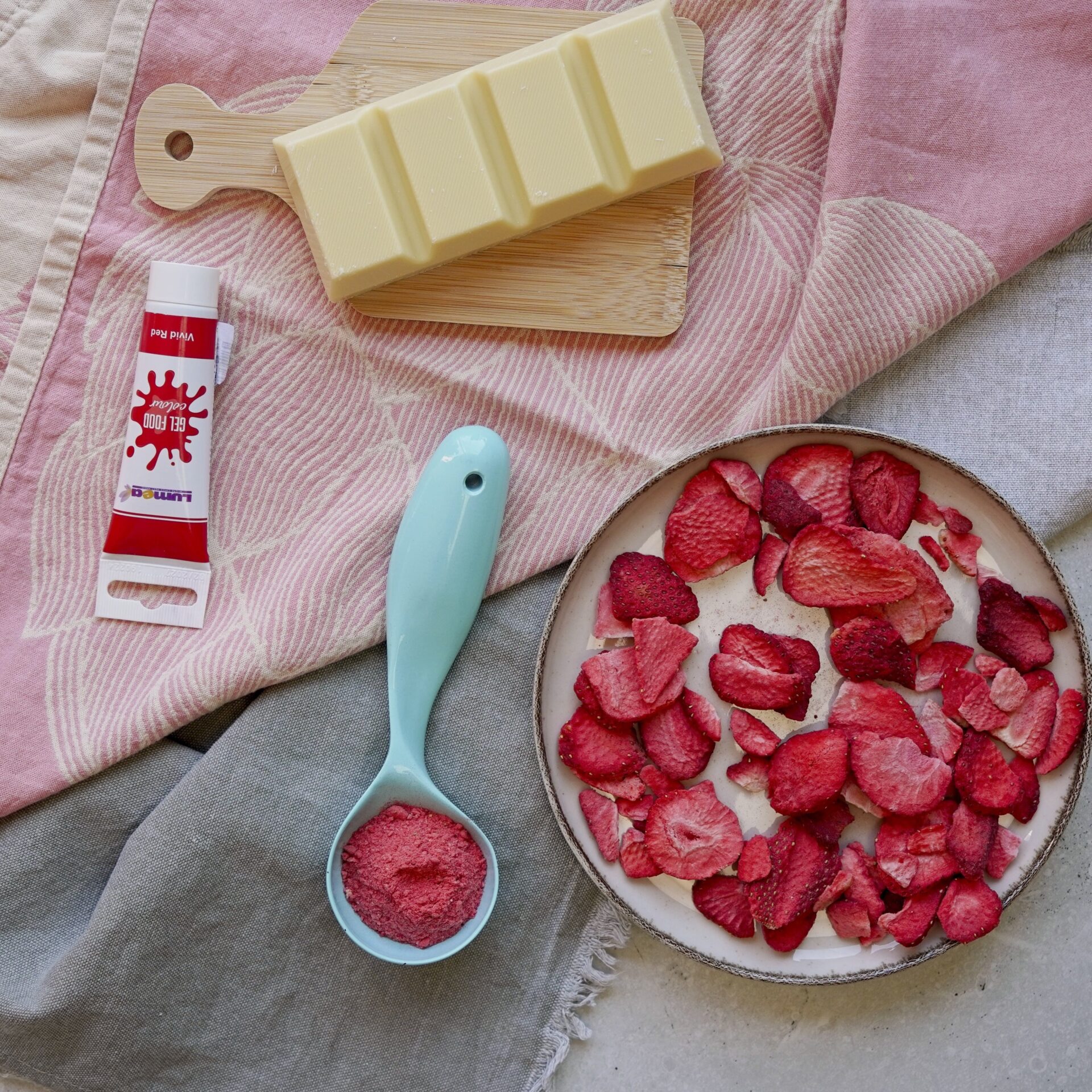 Ingredients you need to make pink chocolate: white chocolate, dried strawberries, and food coloring.