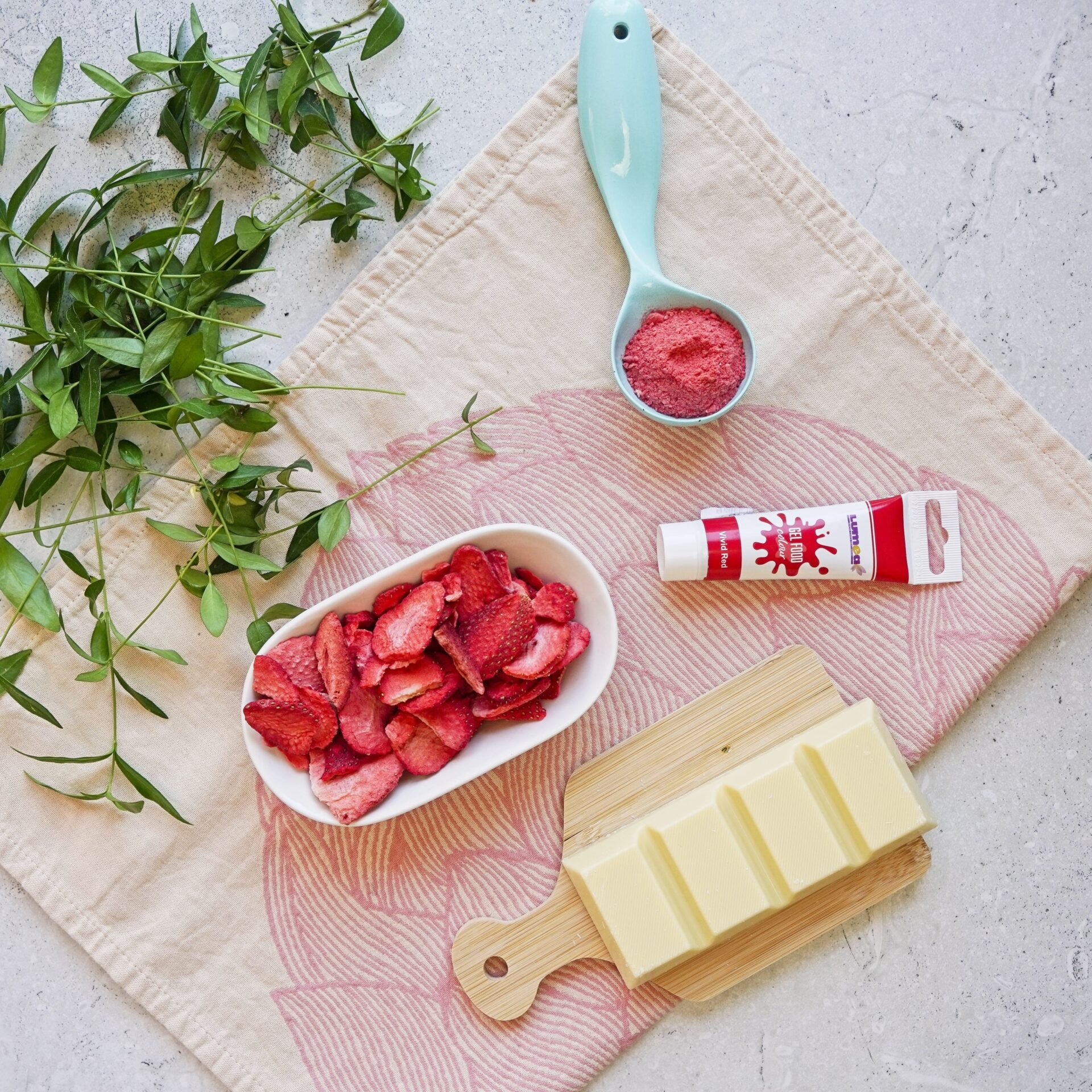 Ingredients for pink chocolate: freeze-dried strawberries for natural coloring, and oil-based red food coloring for coloring with food dye.