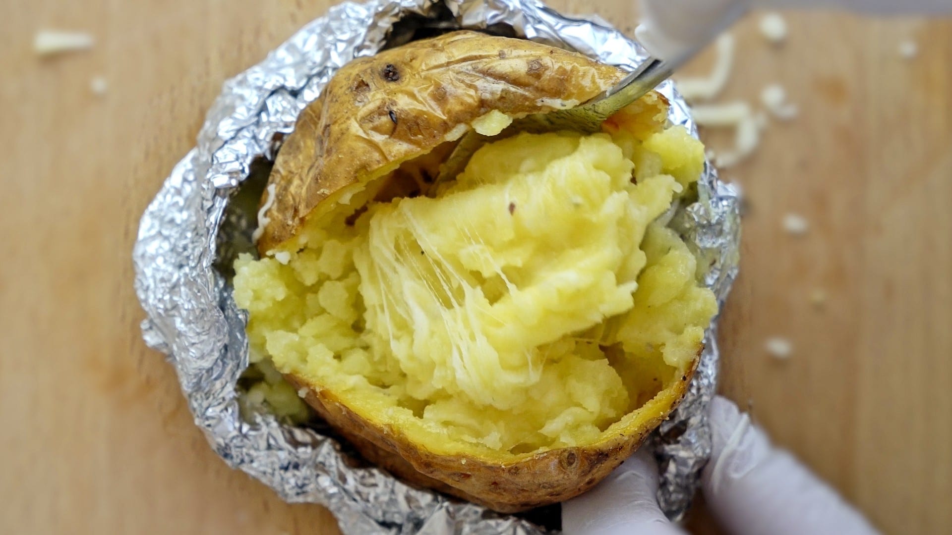 Mixing butter and cheese before freezing baked potatoes.