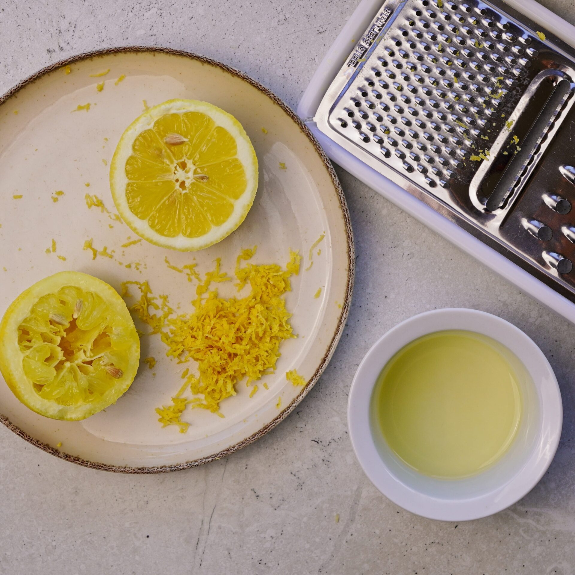 Lemon cut in half, with lemon zest and lemon juice shown from above.