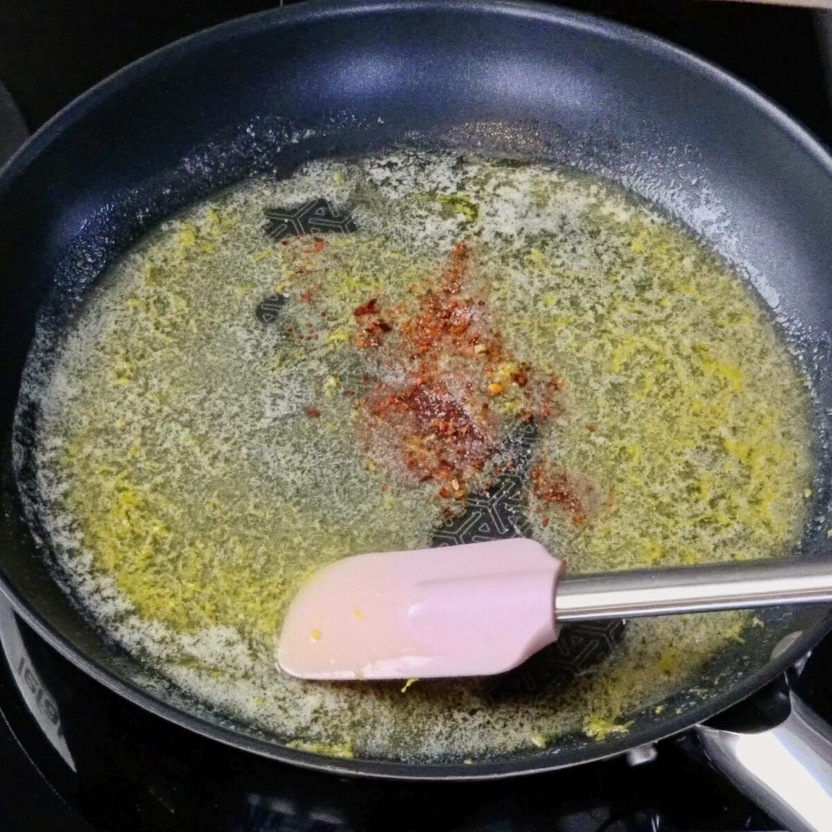 Adding spices to melted butter in a pan.