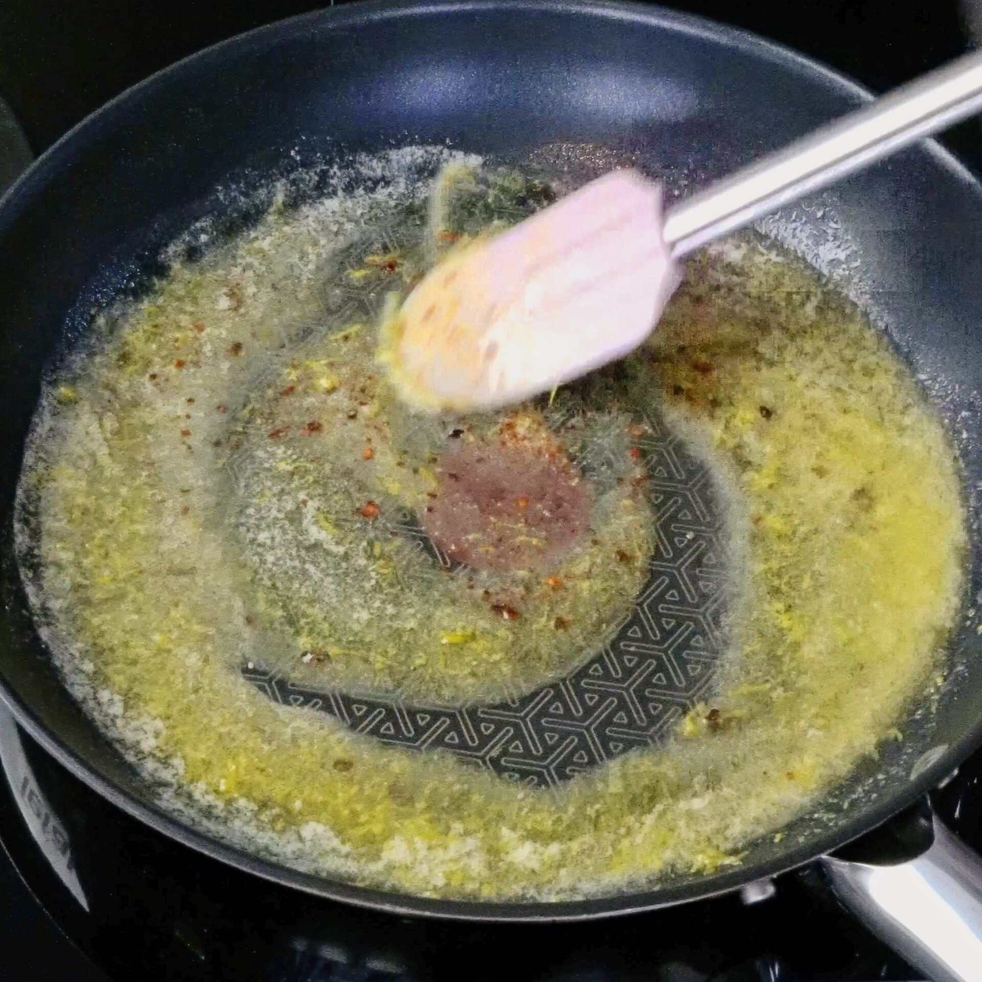 Stirring spices into melted butter in a pan.