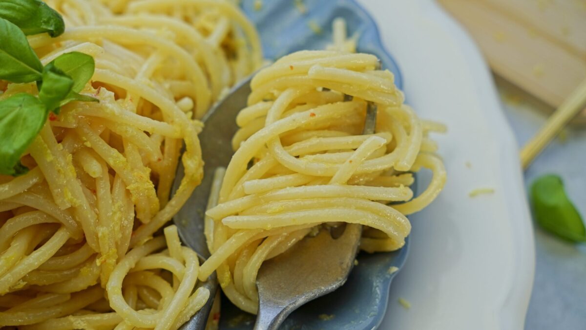 Close-up of pasta in lemon butter cream sauce twirled on a fork.