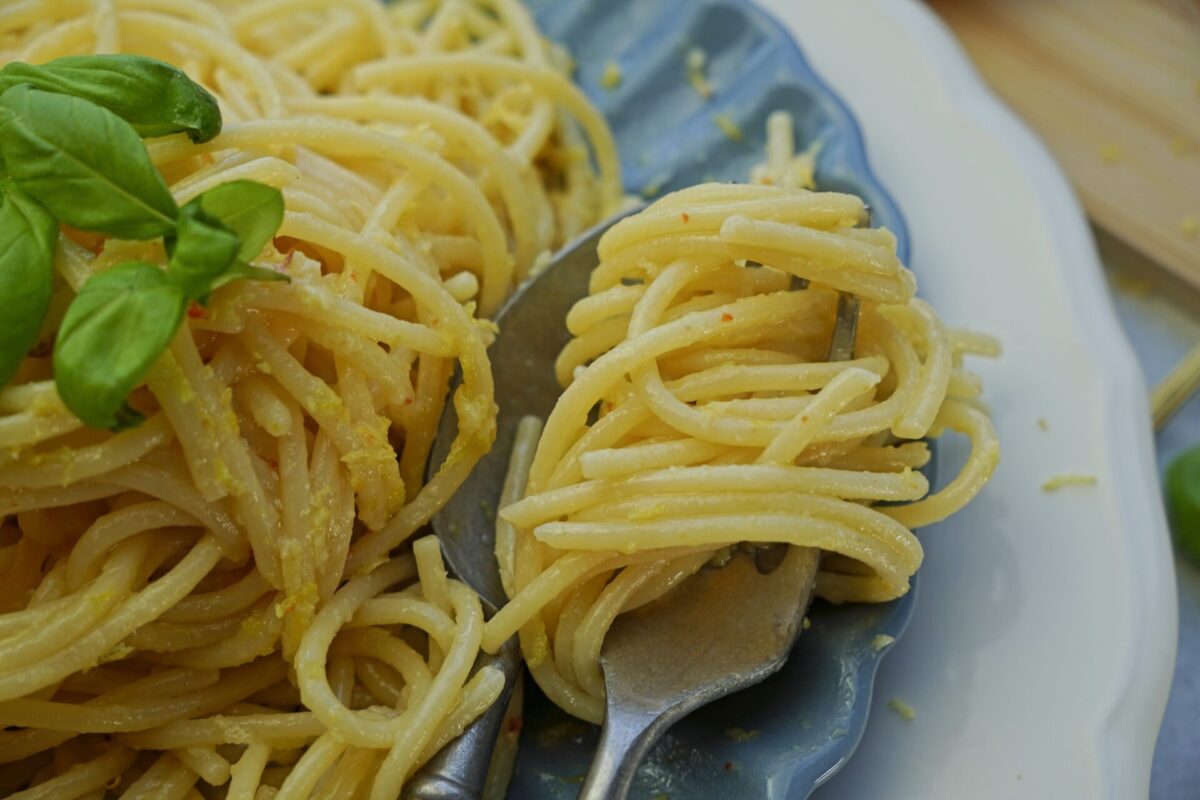 Close-up of creamy lemon butter pasta twirled on a fork, ready to eat.