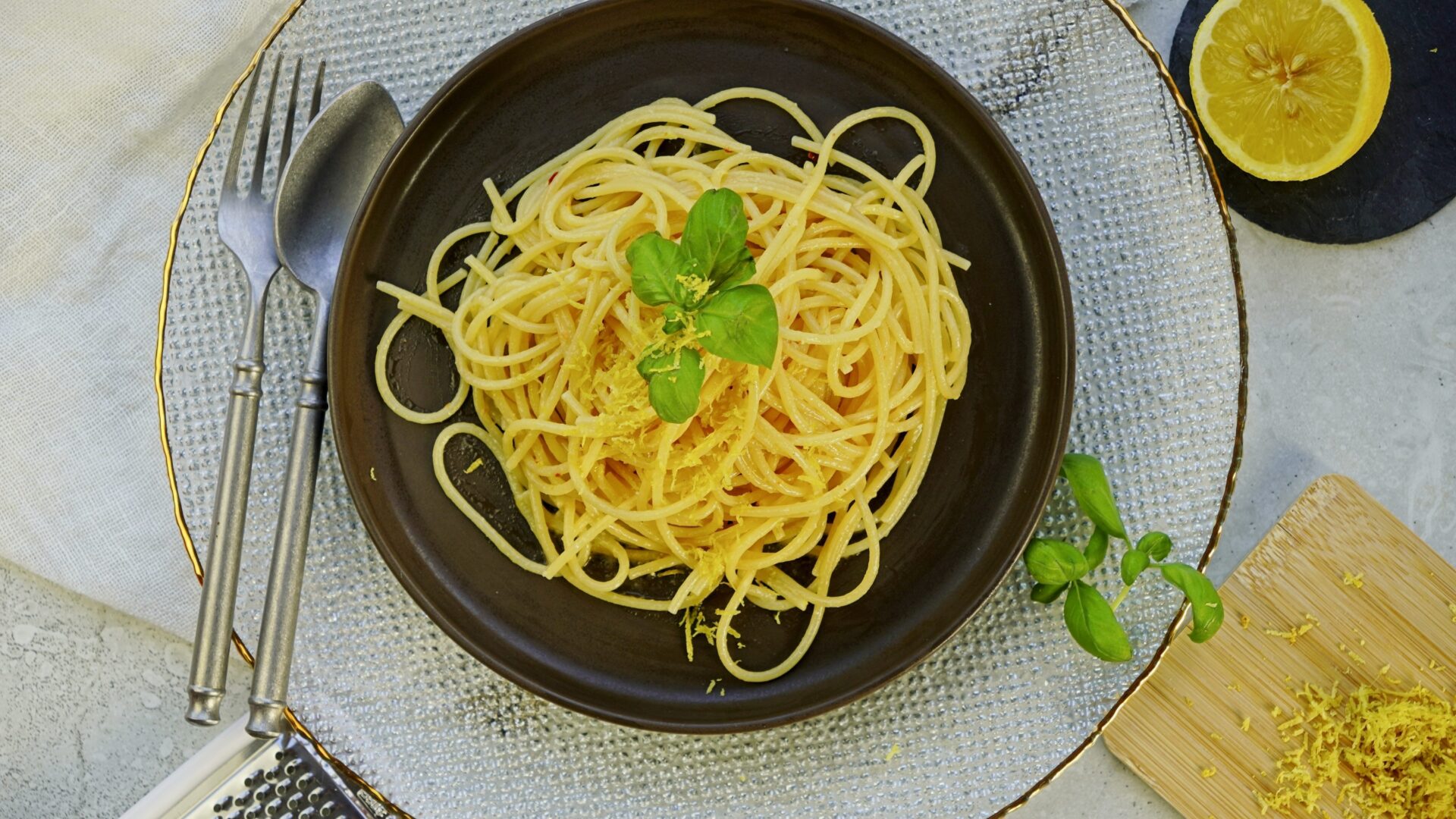 Top-down view of lemon butter cream sauce for pasta, garnished with lemon zest and a lemon wedge on the side.