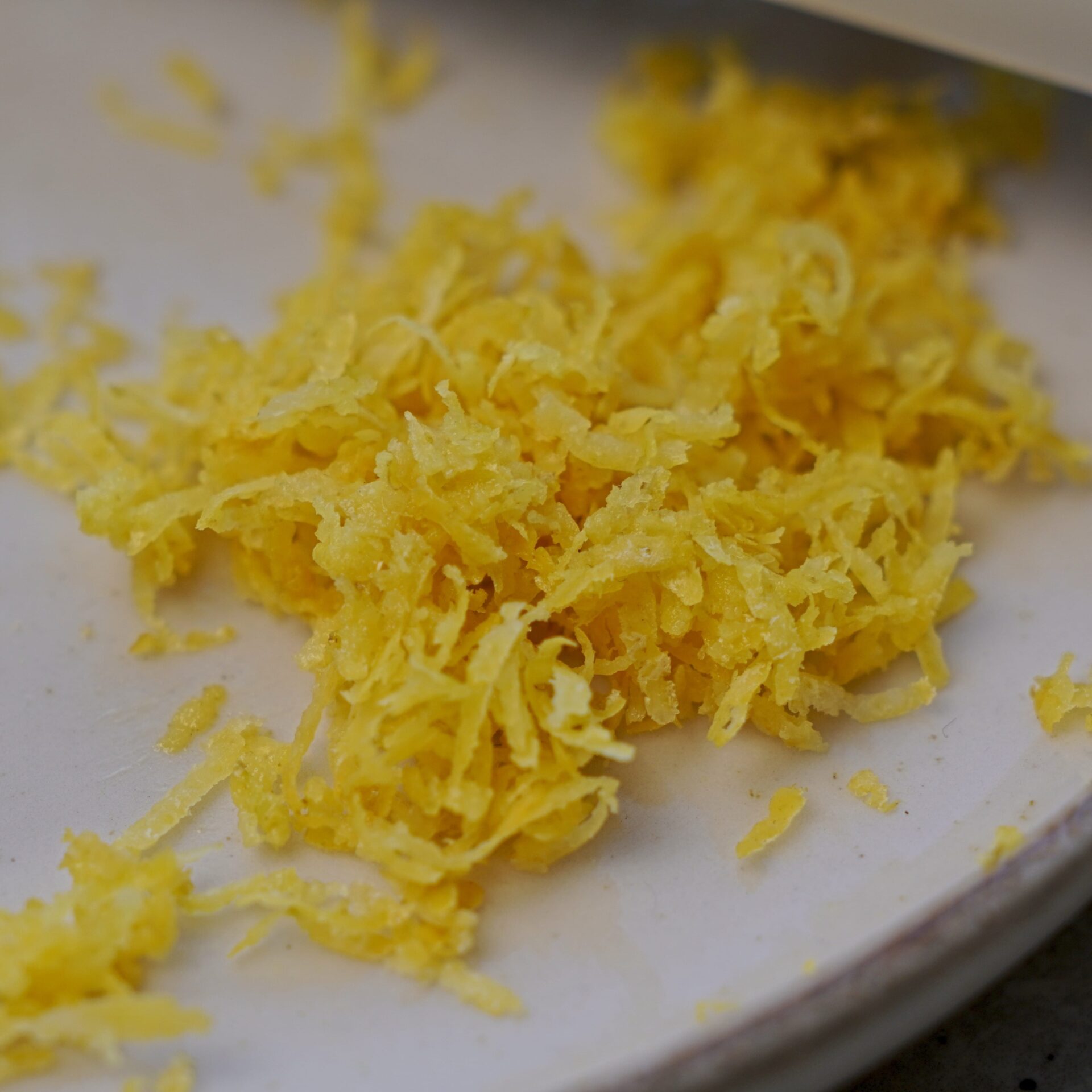Close-up of freshly grated lemon zest, full of bright, fresh flavor.