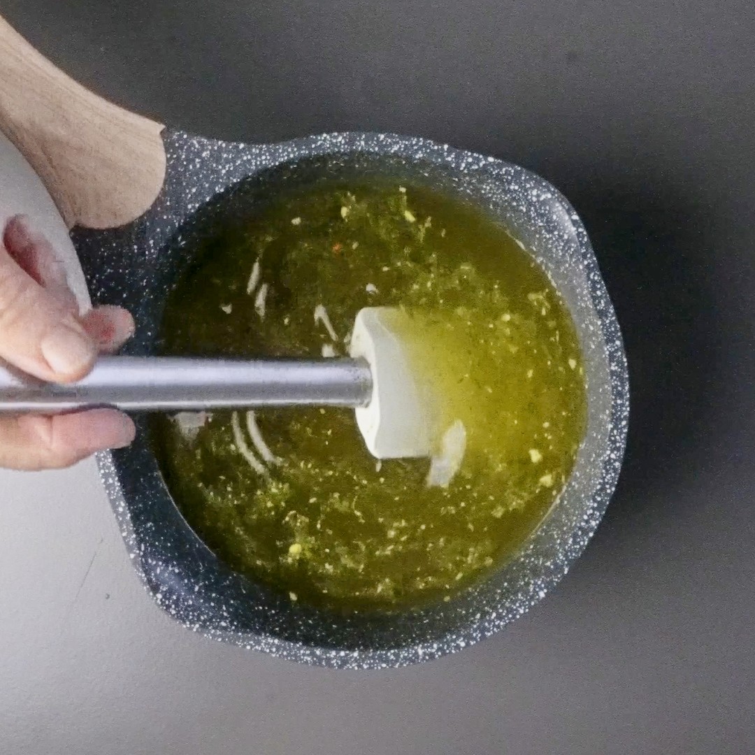 Stirring dry bouillon into water before adding it to the soup.