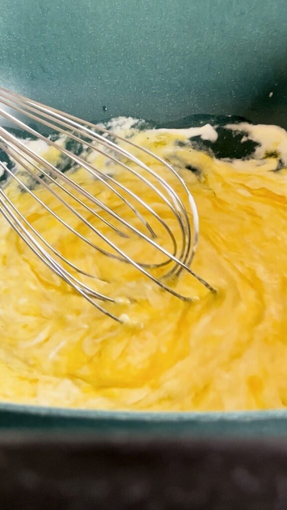 Mixing eggs and buttermilk with a whisk.