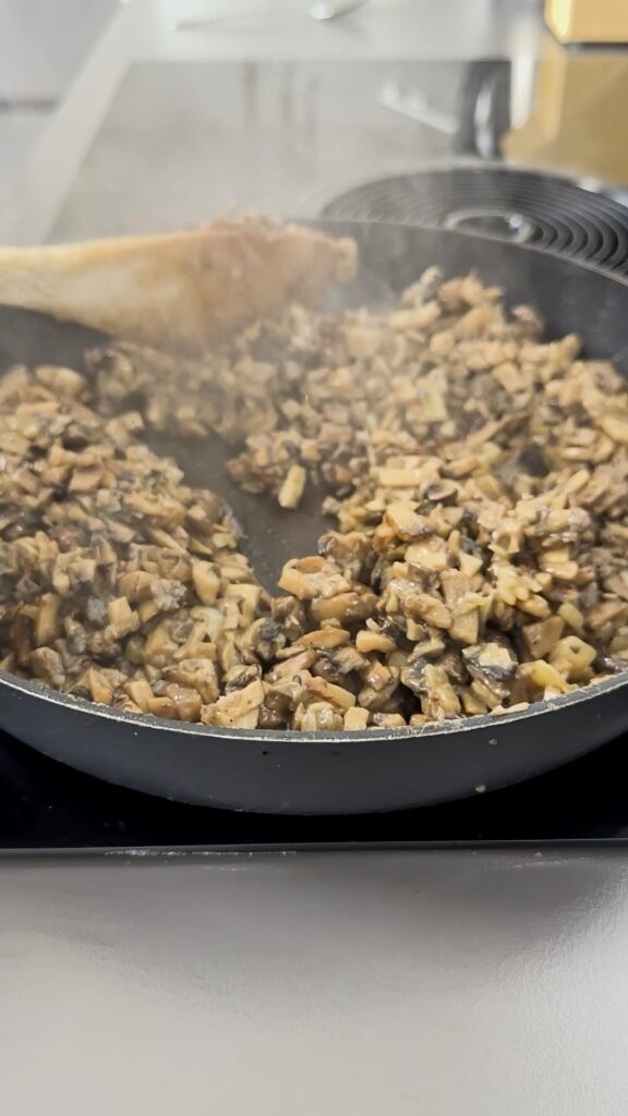 Frying mushrooms in a pan on a high heat. Mushrooms are cut into cubes.