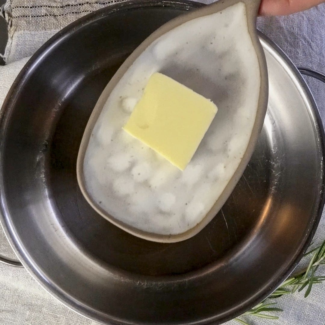 Adding butter to the oil in the pot.