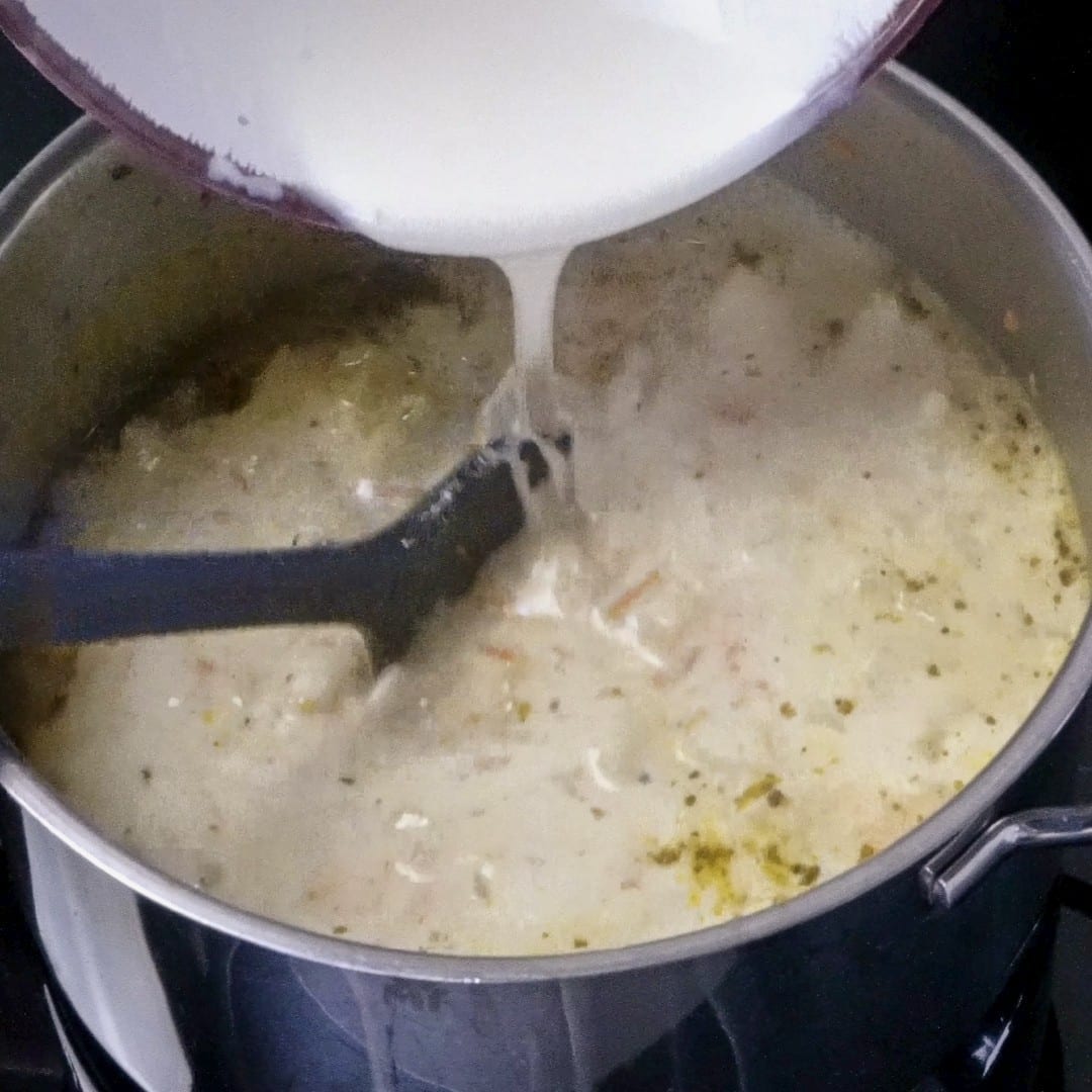 Mixing the heavy cream and flour mixture into the soup.