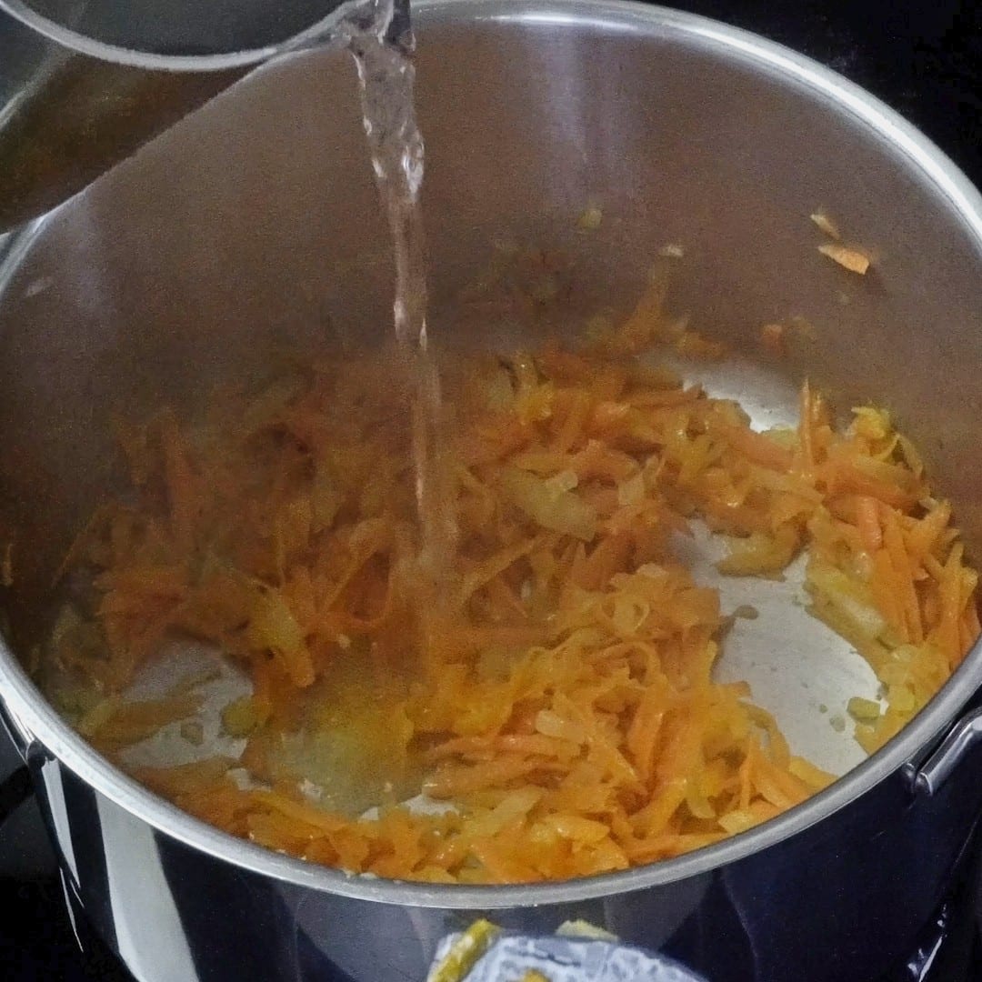 Adding a splash of water to carrots and onions.