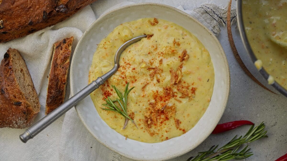 Cheddar potato soup in a bowl, topped with crispy fried onions.